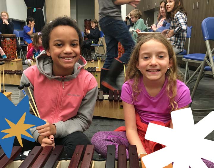 two kids a boy and girl sitting on the smiling at the camera
