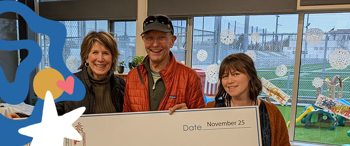 Header image of school administers receiving a donation check